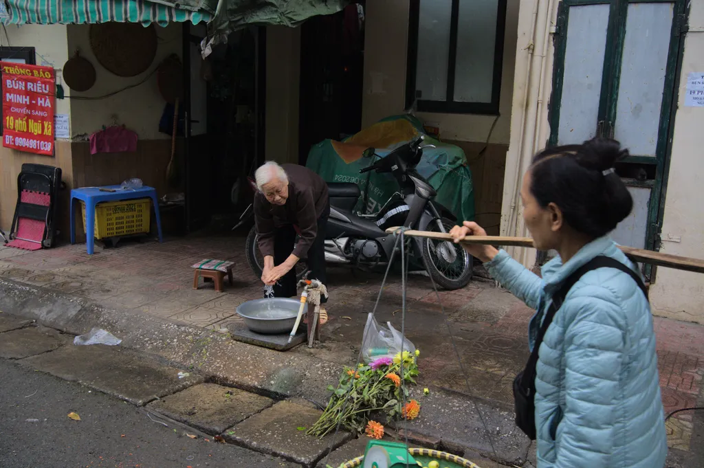 Woman cleaning her hands while a peddler walks nearby
