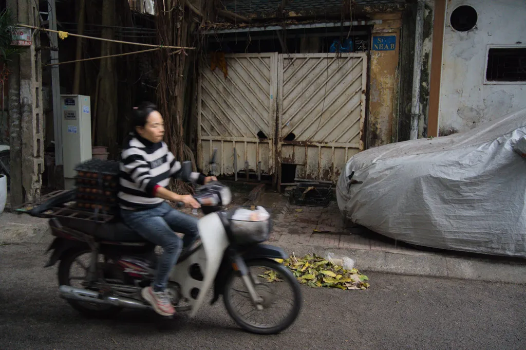 Woman carrying eggs on a motorbike