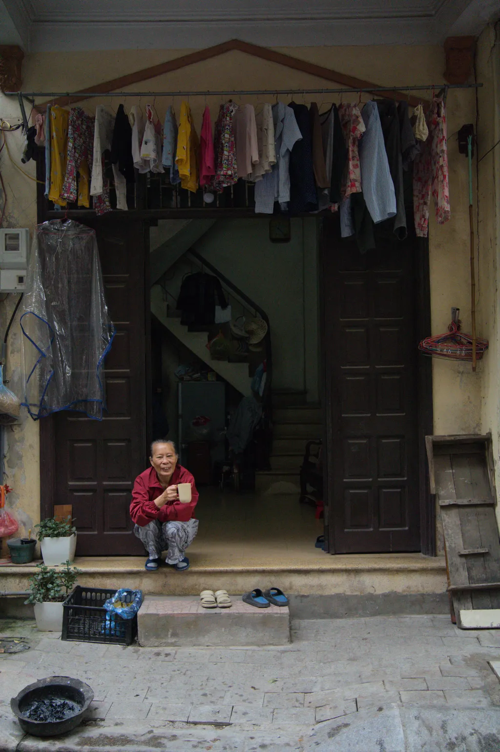 Woman drinking coffee outside of her house